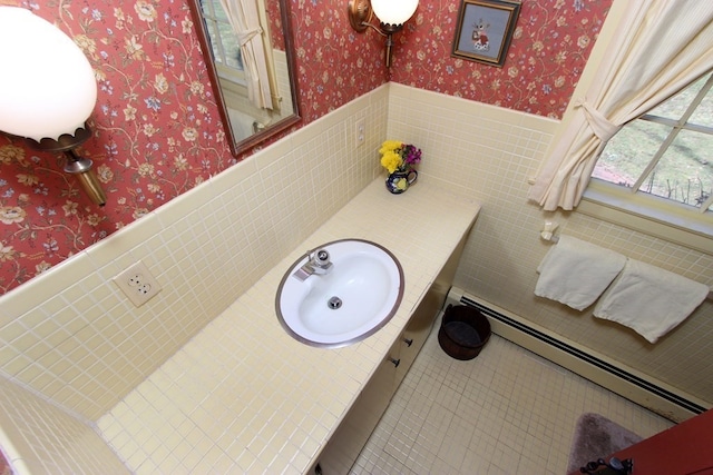 bathroom featuring baseboard heating, tile flooring, vanity, backsplash, and tile walls