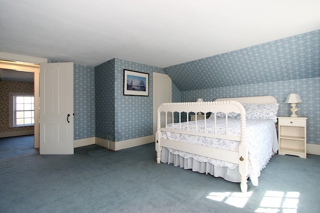 bedroom with dark carpet and vaulted ceiling