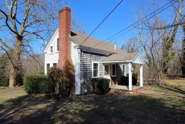 back of property with a porch and a lawn