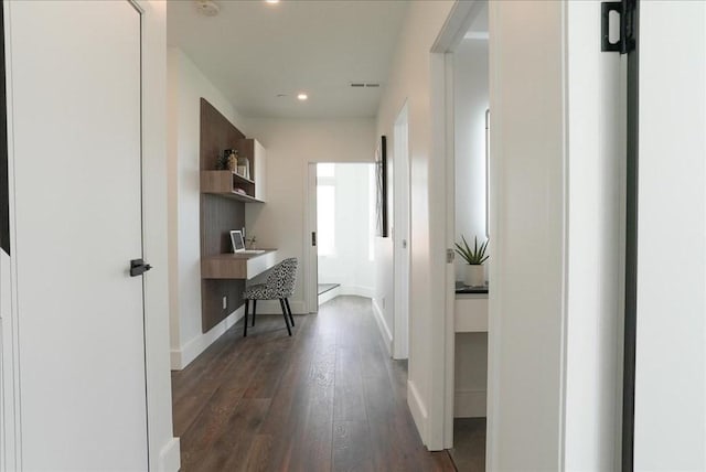 corridor featuring baseboards, dark wood-style floors, visible vents, and recessed lighting