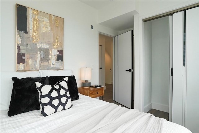 bedroom with a closet, baseboards, and wood finished floors
