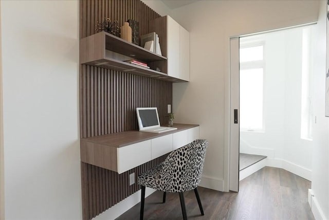 home office with plenty of natural light, dark wood-style flooring, and baseboards