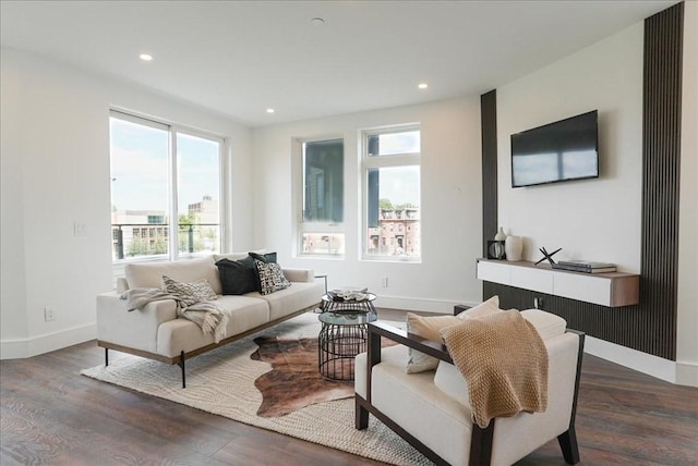 living area with plenty of natural light, baseboards, and wood finished floors