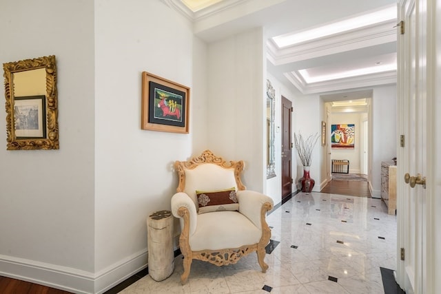 sitting room with light tile floors, a tray ceiling, and ornamental molding