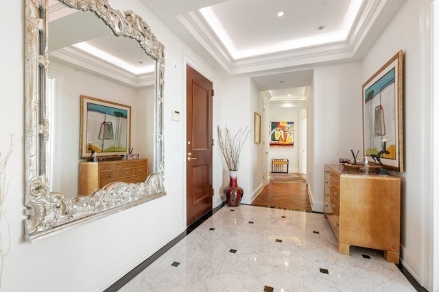 corridor with light tile flooring, a raised ceiling, and ornamental molding