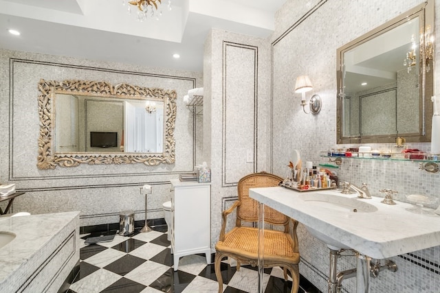 bathroom featuring an inviting chandelier, tile flooring, tile walls, tasteful backsplash, and vanity with extensive cabinet space