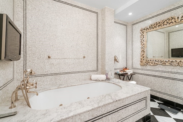 bathroom with tile walls, tile flooring, large vanity, and tiled tub