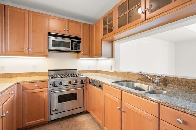 kitchen with light stone countertops, light tile flooring, sink, and stainless steel appliances