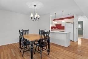 dining room featuring light wood-type flooring and a notable chandelier