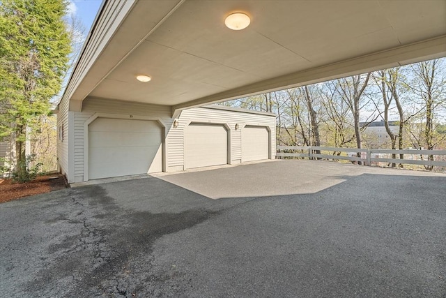 garage with fence and driveway