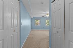 hall with baseboards and carpet floors