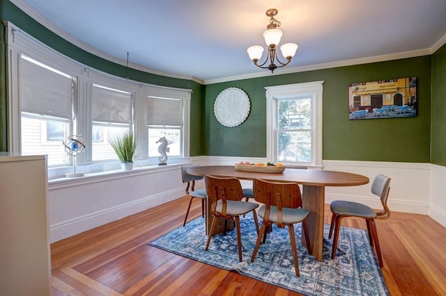 dining room featuring light hardwood / wood-style floors, ornamental molding, and a chandelier