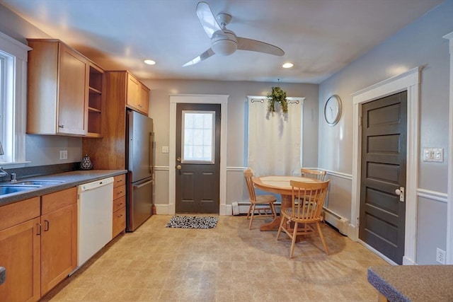 kitchen featuring baseboard heating, ceiling fan, white dishwasher, sink, and stainless steel refrigerator