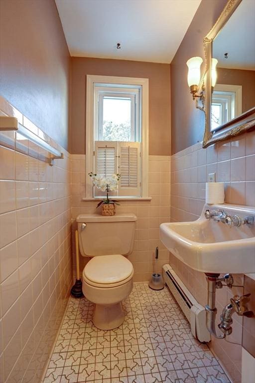 bathroom featuring tile patterned floors, toilet, and tile walls