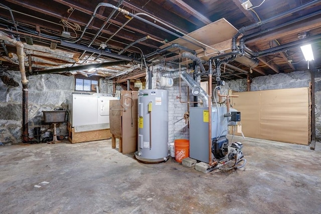 basement featuring sink, independent washer and dryer, and water heater