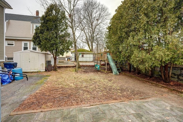 view of yard with a playground and a storage shed