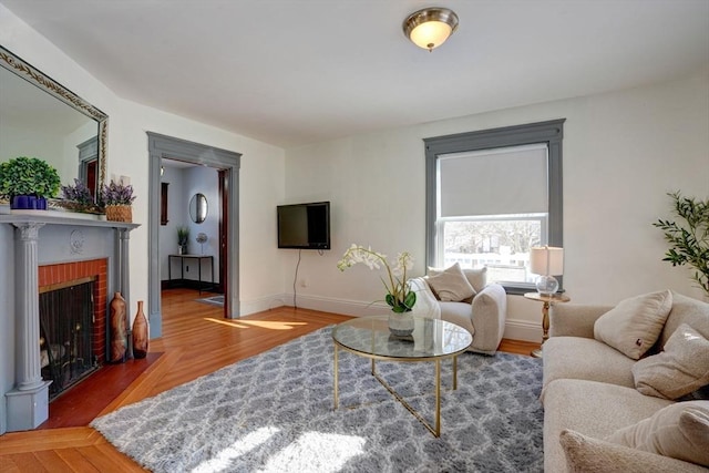 living room featuring hardwood / wood-style flooring and a brick fireplace