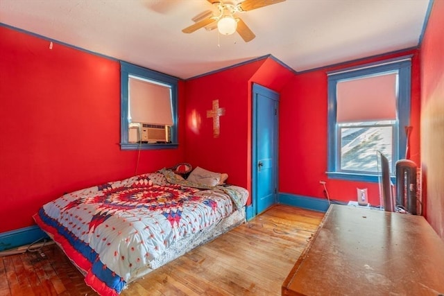 bedroom featuring hardwood / wood-style flooring, ceiling fan, and cooling unit