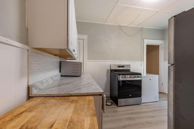 kitchen with white cabinetry, light hardwood / wood-style flooring, and appliances with stainless steel finishes