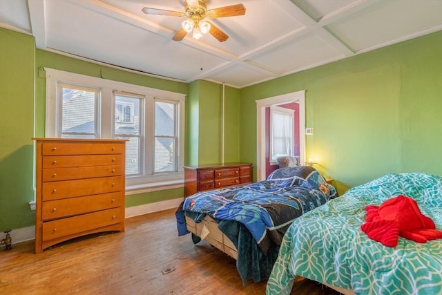 bedroom with hardwood / wood-style flooring, ceiling fan, and coffered ceiling