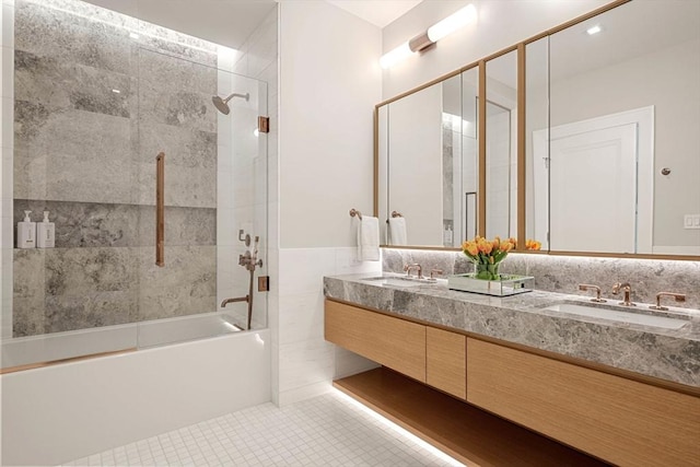 full bath with double vanity, shower / bathtub combination, a sink, and tile patterned flooring
