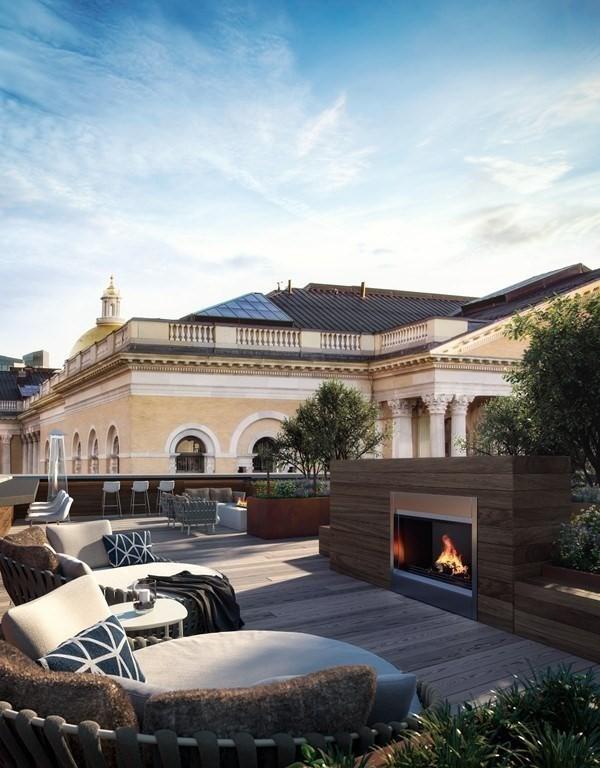 back of house featuring a lit fireplace and a deck