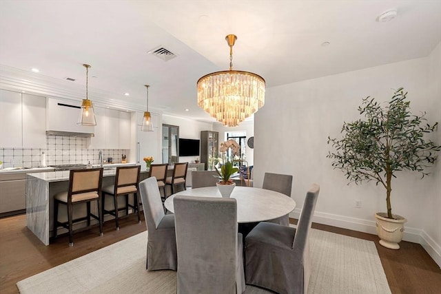 dining area with an inviting chandelier, baseboards, recessed lighting, and light wood finished floors