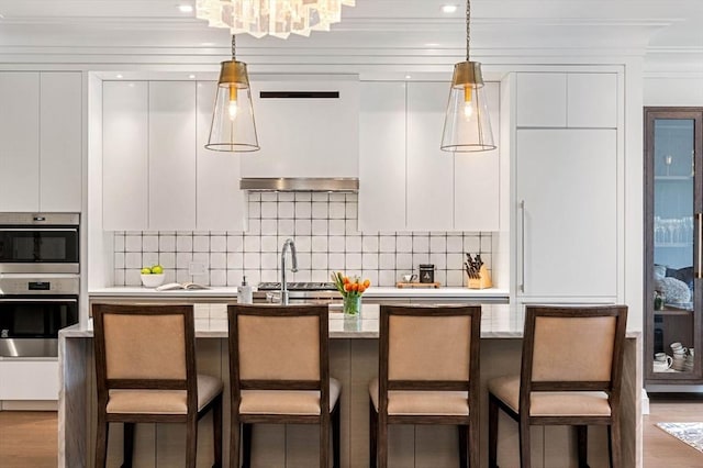 kitchen featuring light countertops, stainless steel double oven, white cabinetry, and decorative light fixtures