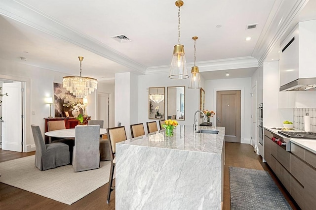 kitchen featuring a sink, modern cabinets, stainless steel gas stovetop, and an inviting chandelier