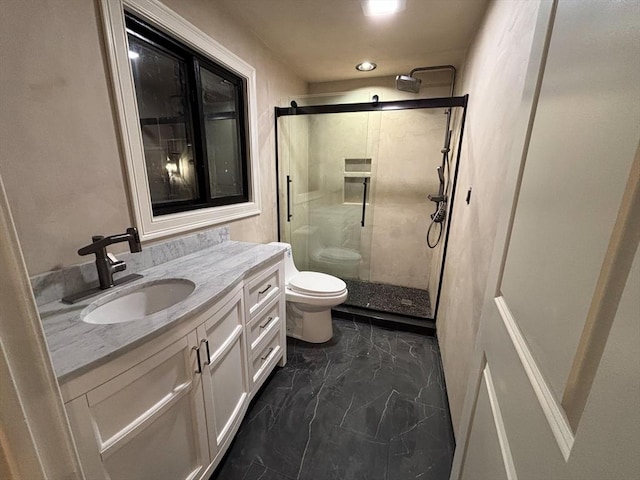 bathroom featuring a shower with door, toilet, and vanity