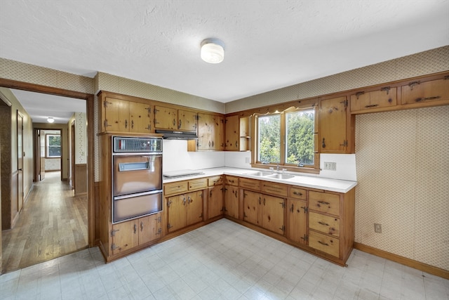 1032 Tinkham Rd, Wilbraham, MA 01095 - kitchen with wall oven, wallpapered walls, a warming drawer, light countertops, and baseboards