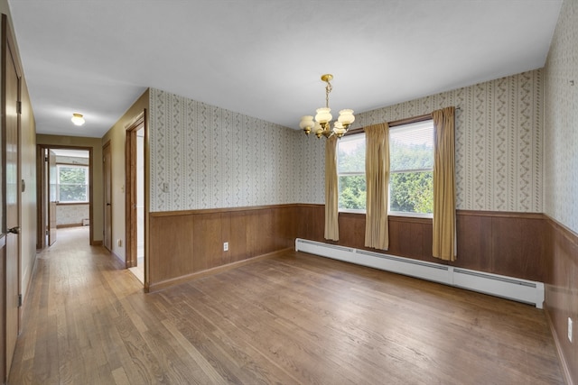 1032 Tinkham Rd, Wilbraham, MA 01095 - unfurnished room with a baseboard heating unit, a chandelier, wainscoting, wood finished floors, and wallpapered walls