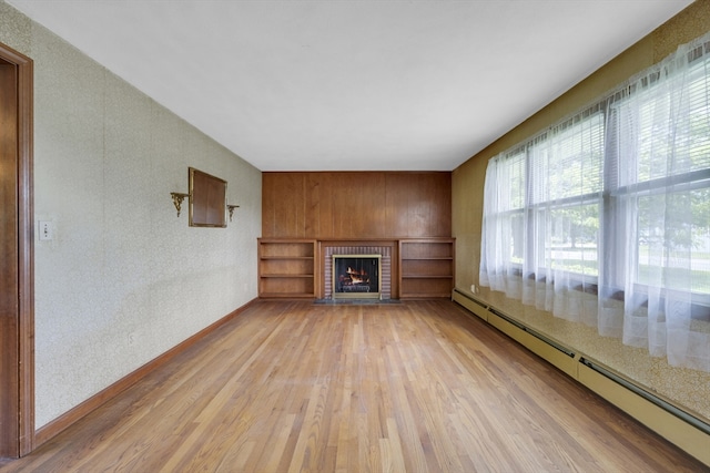 1032 Tinkham Rd, Wilbraham, MA 01095 - unfurnished living room featuring a baseboard heating unit, light wood-type flooring, a brick fireplace, and baseboards