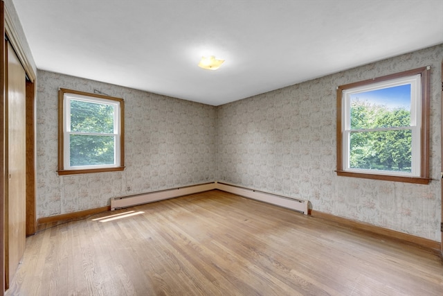 1032 Tinkham Rd, Wilbraham, MA 01095 - spare room featuring light wood finished floors, baseboards, wallpapered walls, and a baseboard radiator