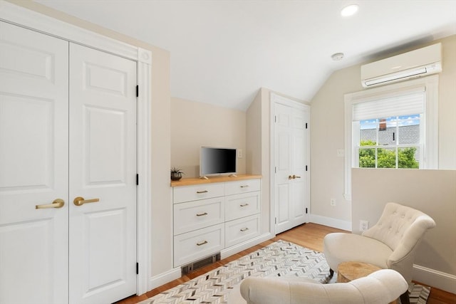 17 Perry St, Somerville, MA 02143 - living area with a wall unit AC, vaulted ceiling, baseboards, light wood-style floors, and recessed lighting