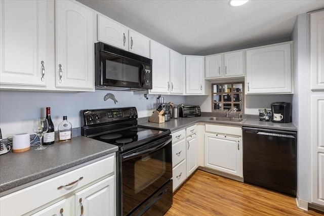 kitchen featuring black appliances, white cabinetry, sink, and light hardwood / wood-style flooring