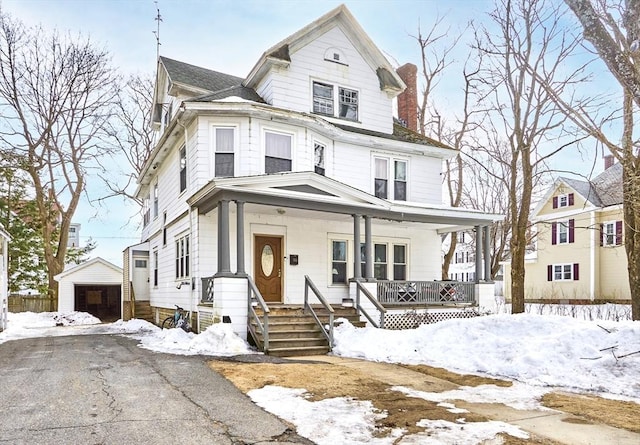 view of front of property with a porch, a chimney, and a garage