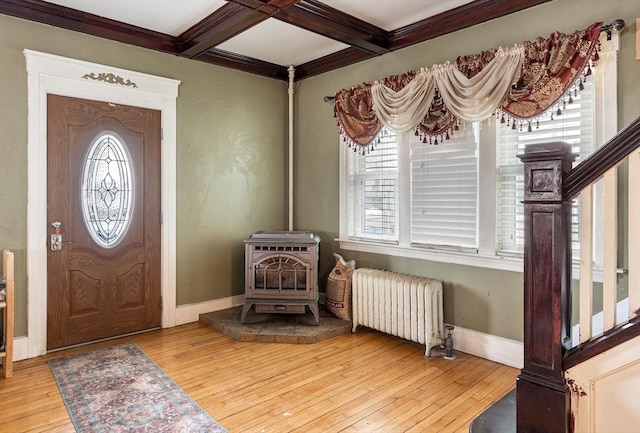 entryway featuring a wealth of natural light, radiator, a wood stove, coffered ceiling, and hardwood / wood-style floors