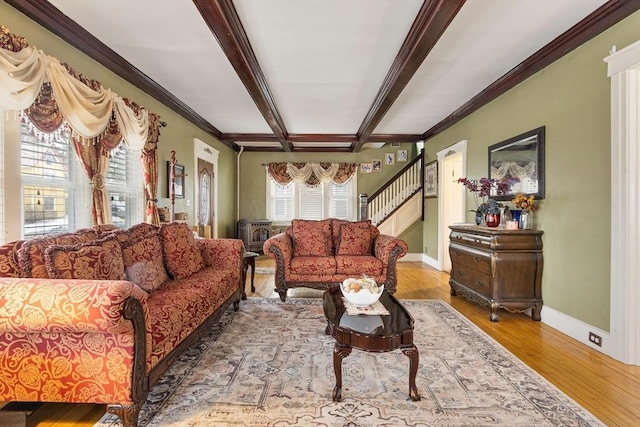 living room with beam ceiling, ornamental molding, wood finished floors, baseboards, and stairs