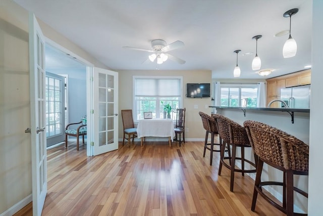 kitchen featuring stainless steel fridge with ice dispenser, french doors, a breakfast bar area, and plenty of natural light