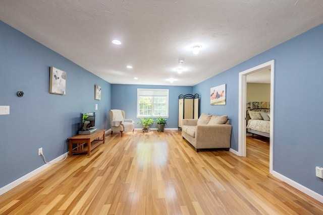living area featuring light wood-style floors, baseboards, and recessed lighting