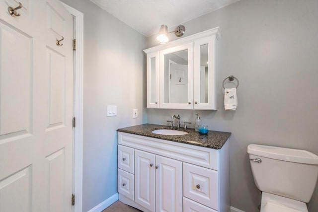 bathroom with vanity, toilet, and baseboards