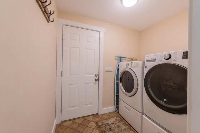laundry area with separate washer and dryer, baseboards, and light tile patterned floors