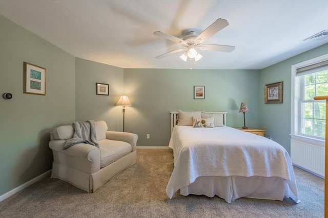 carpeted bedroom with radiator, baseboards, and ceiling fan