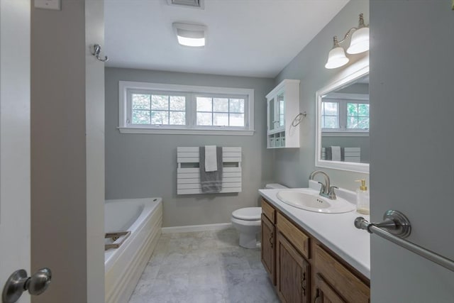 full bathroom featuring healthy amount of natural light, toilet, a tub, and vanity