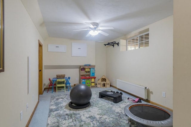 playroom with radiator heating unit, a ceiling fan, and baseboards