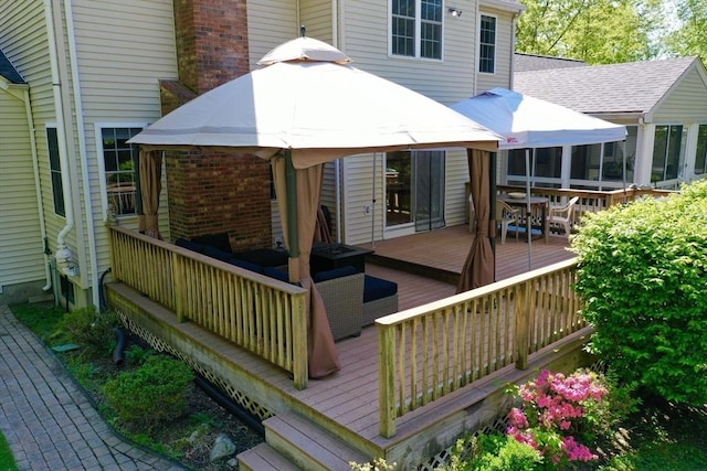 back of house featuring a wooden deck, outdoor dining space, a gazebo, brick siding, and roof with shingles