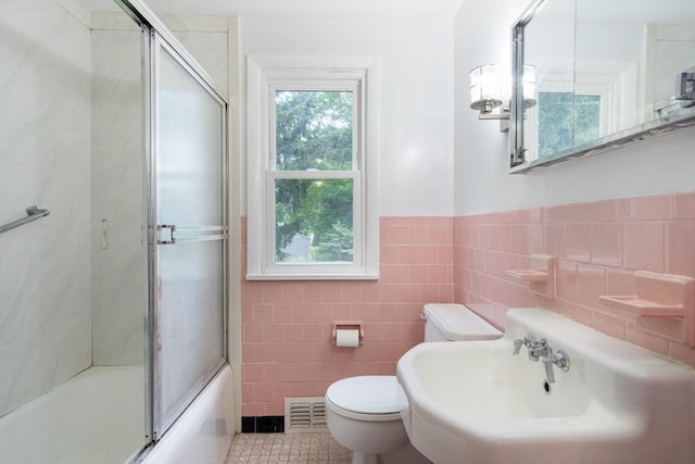 31 Melwood Ave, East Longmeadow, MA 01028 - bathroom with tile walls, bath / shower combo with glass door, tile patterned floors, and a wainscoted wall