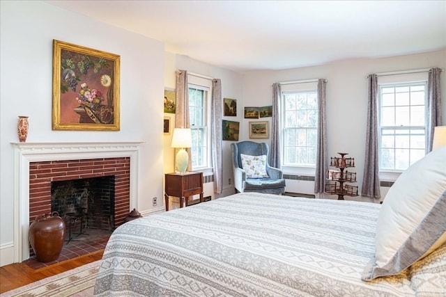 bedroom with a fireplace and dark hardwood / wood-style floors