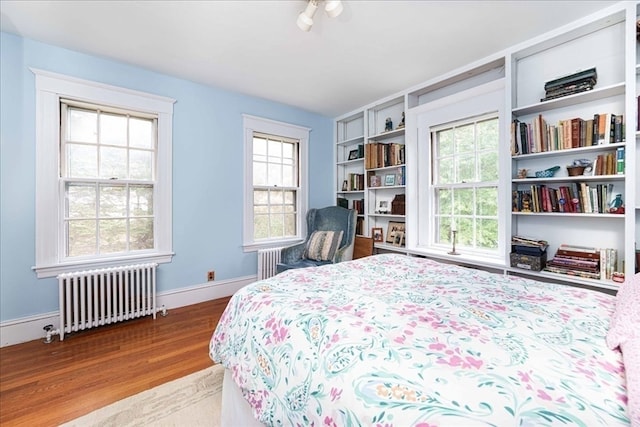 bedroom with radiator heating unit and light hardwood / wood-style floors